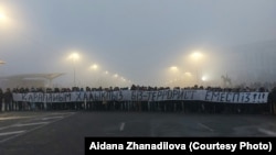 Республика алаңында "Қарапайым халықпыз. Біз — террорист емеспіз!" деген жазу ұстап тұрған адамдар. Алматы, 6 қаңтар 2022 ж.