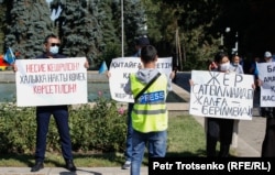 "PRESS" деген жазу жапсырған кеудеше киген журналист митингіге қатысушыларды суретке түсіріп тұр. Алматы, 13 қыркүйек 2020 жыл.