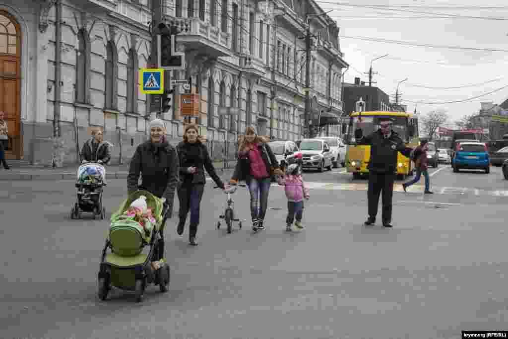 Светофорлар істемегендіктен жаяу жүргіншілер көшеден реттеуші көмегімен өтеді. &nbsp;