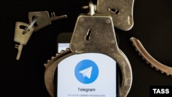 Кісенге салынған Telegram қосымшасы орнатылған смартфон (Көрнекі сурет). 